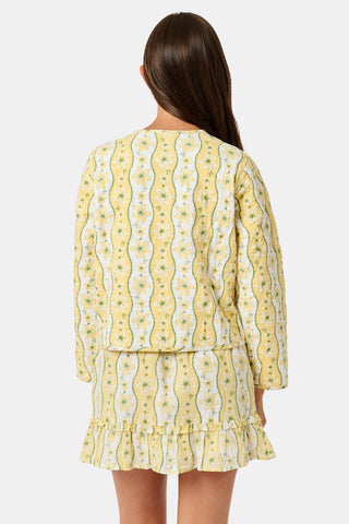 A young girl wearing a Roller Rabbit Kids Lillian Floral Stripe Finn Jacket paired with a matching ruffled skirt and gold ballet flats, standing and smiling against a plain white background—perfect for back-to-school style.