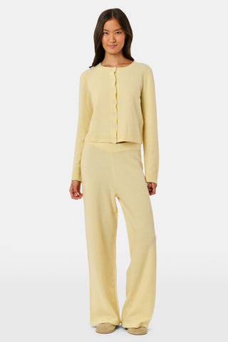 A person wearing the Roller Rabbit Gaia Pant paired with a light yellow knit sweater and beige slippers stands against a plain white background.