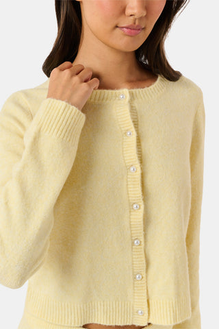 A woman wearing the Roller Rabbit Moxie Cardigan in butter yellow with matching pants, standing against a plain white background.