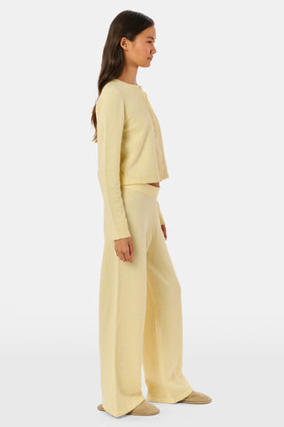 A person wearing the Roller Rabbit Gaia Pant paired with a light yellow knit sweater and beige slippers stands against a plain white background.
