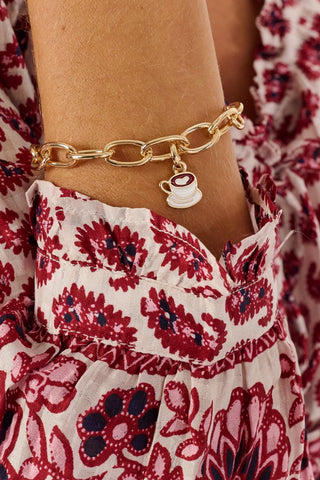 MADISON 501 Latte Charm shaped like a coffee cup and saucer with white enamel and a red heart-shaped detail.