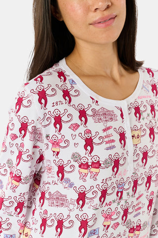 The Alpha Phi Monkey Pajamas by Roller Rabbit are a long-sleeve pajama set crafted from soft Pima cotton, featuring a red and gray cartoon animal print on a white background, with a Henley top and matching pants.