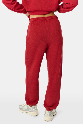 Holly berry red US BLANKS Deck The Halls Bea Sweatpants featuring a small embroidered graphic of a green character wearing a holiday sweater on the right hip.