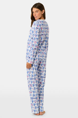 A woman in Roller Rabbit Delta Gamma Monkey Pajamas sits on steps, eating from a cup of ice cream topped with rainbow sprinkles using a white plastic spoon.