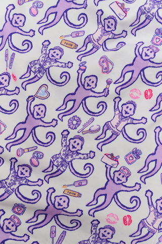 A woman smiles while wearing the TEXPIMA Get Ready With Me Blake Robe, featuring a knee-length cut and a purple and pink paisley pattern, tied at the waist, against a plain white background.