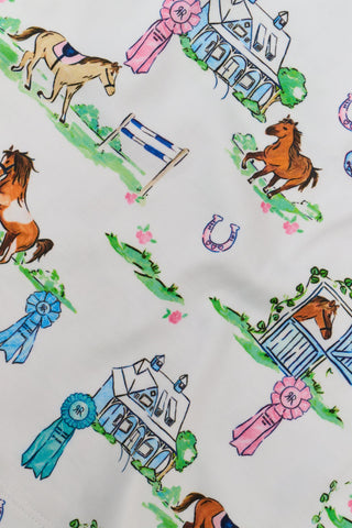 The Saddle Up Joanie Pajamas by Roller Rabbit feature a white sleeveless top and long pants with pink trim. Both pieces are made from soft Pima cotton and decorated with colorful cartoon animal and house prints scattered across the fabric.