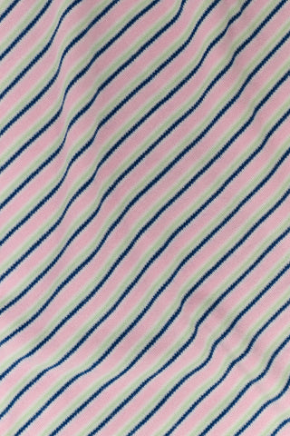 A woman wearing the Roller Rabbit Striped Steph Tee—a short-sleeve, white Pima Cotton pajama top featuring thin horizontal navy and pink stripes and a light pink collar—stands against a plain background.