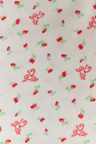 A woman wears the Roller Rabbit Mini Monkey Blossom Pointelle Tara Short as part of a matching pajama set with a white base and pink floral and animal prints, lifting her top slightly to reveal the waistband of the vintage-style tap shorts. Only her torso and upper thighs are visible.
