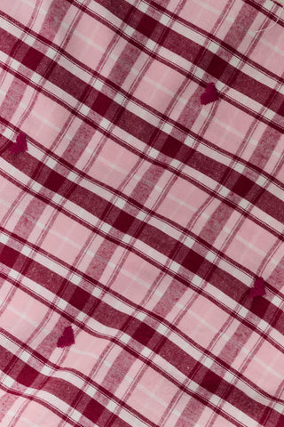 A woman wearing a SAPPHIRE Plaid Hearts Perlita Night Shirt in a pink and maroon plaid pattern with small hearts.