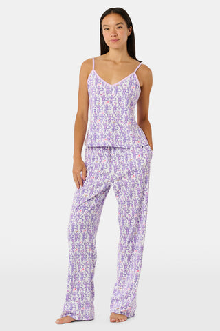 A woman smiles while wearing the TEXPIMA Get Ready With Me Blake Robe, featuring a knee-length cut and a purple and pink paisley pattern, tied at the waist, against a plain white background.