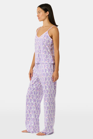 A woman smiles while wearing the TEXPIMA Get Ready With Me Blake Robe, featuring a knee-length cut and a purple and pink paisley pattern, tied at the waist, against a plain white background.