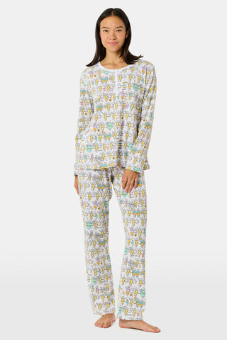 The Roller Rabbit Kappa Alpha Theta Monkey Pajamas set features a white, long-sleeved buttoned top and matching pants, both adorned with a vibrant all-over cartoon print of playful animal characters, including cheerful monkeys.