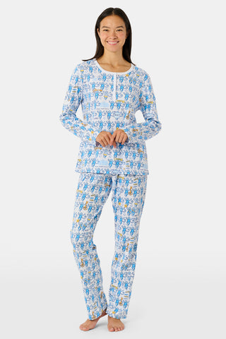 The Roller Rabbit Kappa Kappa Gamma Monkey Pajamas are a two-piece set with long sleeves and pants, showcasing an all-over blue and yellow monkey cartoon print on a white background, displayed on a flat white backdrop.