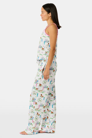The Saddle Up Joanie Pajamas by Roller Rabbit feature a white sleeveless top and long pants with pink trim. Both pieces are made from soft Pima cotton and decorated with colorful cartoon animal and house prints scattered across the fabric.