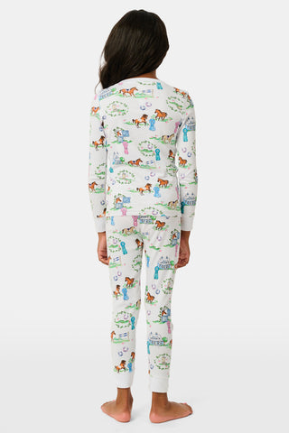 Introducing the Kids Saddle Up Pajamas by Roller Rabbit—a children’s pajama set crafted from premium Pima cotton, featuring a whimsical equestrian print of horses, castles, and greenery on a white background. This high-quality set includes a long-sleeve top and matching pants.