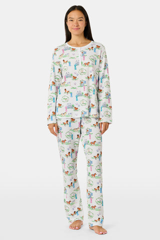 Meet the Saddle Up Pajamas by Roller Rabbit: a long-sleeved Pima cotton set on a white background, adorned with vibrant animal and tree motifs. The top features buttons at the neckline, while the elastic-waist pants offer comfy ease—ideal for horse girls who appreciate playful patterns and cozy comfort.