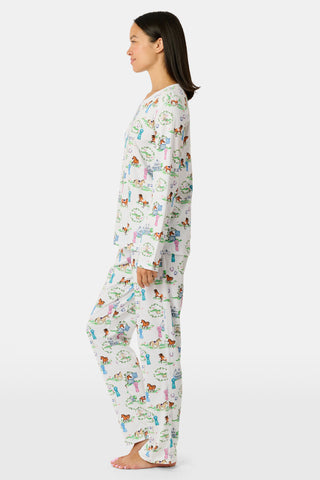 Meet the Saddle Up Pajamas by Roller Rabbit: a long-sleeved Pima cotton set on a white background, adorned with vibrant animal and tree motifs. The top features buttons at the neckline, while the elastic-waist pants offer comfy ease—ideal for horse girls who appreciate playful patterns and cozy comfort.