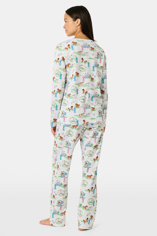 Meet the Saddle Up Pajamas by Roller Rabbit: a long-sleeved Pima cotton set on a white background, adorned with vibrant animal and tree motifs. The top features buttons at the neckline, while the elastic-waist pants offer comfy ease—ideal for horse girls who appreciate playful patterns and cozy comfort.