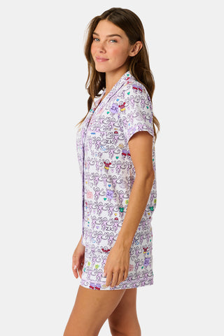The Sigma Kappa Monkey Polo Pajamas by Roller Rabbit are a short-sleeve pajama set featuring matching shorts with a white background and colorful cartoon character pattern. Designed for comfort, they include a front button placket and an elastic waistband.