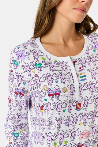 The Sigma Kappa Monkey Pajamas by Roller Rabbit is a long-sleeve set featuring a buttoned top and comfortable elastic waist, decorated with an all-over pattern of colorful cartoon monkey faces on a white background.