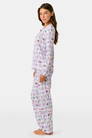 The Sigma Kappa Monkey Pajamas by Roller Rabbit is a long-sleeve set featuring a buttoned top and comfortable elastic waist, decorated with an all-over pattern of colorful cartoon monkey faces on a white background.