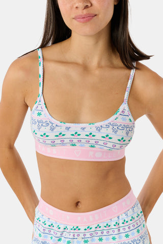 A Snowday Stripe Sarah Scoop Bralette featuring a print of monkeys, holly, and hearts, with a pink elastic band labeled RABBIT HEART ROLLER.