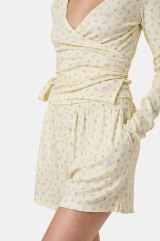 The Mini Monkey Blossom Brooklyn Boxer by Roller Rabbit features light yellow Pima cotton with a delicate pastel floral print and an elastic waistband. Displayed on a plain white background, these comfortable women’s loungewear sleep shorts are perfect for relaxing at home.