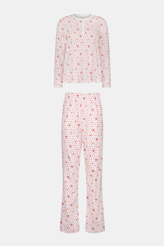 A person stands facing forward, barefoot against a plain white background, wearing Roller Rabbit’s Autumn Hearts Pajamas—women’s long-sleeve and long-pant pajamas crafted from soft Pima cotton in a pink and white polka-dot print.
