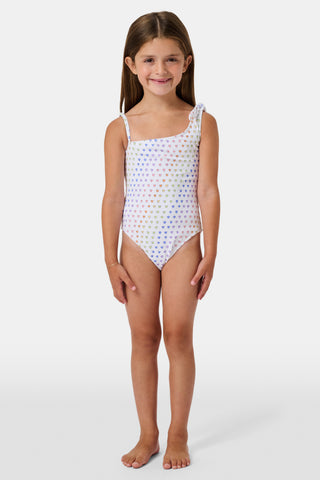 The Disco Hearts Kids Jacey One Piece by Roller Rabbit is a white swimsuit with rows of colorful hearts, featuring an asymmetrical neckline, one thin strap, and a knot-tie detail on the right shoulder.