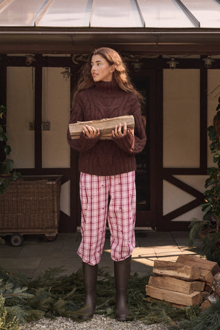 A woman wearing a SAPPHIRE Plaid Hearts Perlita Night Shirt in a pink and maroon plaid pattern with small hearts.