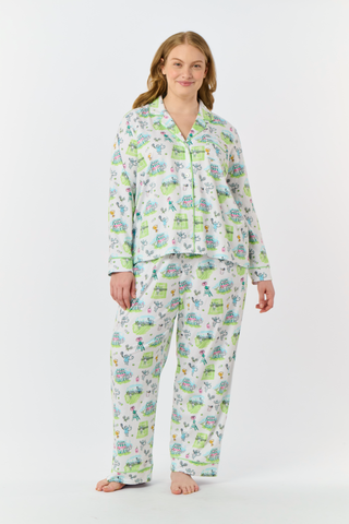 Introducing the Game, Set, Monkey Long Sleeve Polo Pajamas by Roller Rabbit—a cozy white pajama set expertly crafted from soft Pima Cotton. The set features a playful Game Set Monkey print with vibrant green, blue, and yellow animal and nature illustrations. Designed with long sleeves, a button-up polo top, and comfortable drawstring waist pants, this delightful set is showcased against a plain light background.