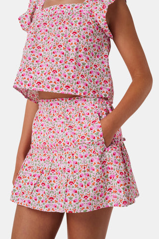 A Roller Rabbit Kids Garden Gate Floral Alexis Skirt with matching briefs, both showcasing a pink, green, and white flower pattern, is displayed on a plain white background. This cotton skirt is ideal for girls who love playful floral prints.