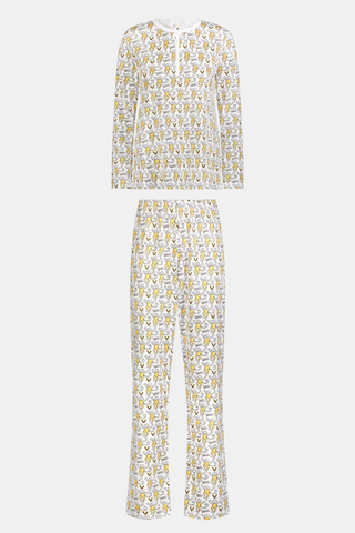 A person stands barefoot wearing the SERFLEX Vanderbilt Lovely Monkey Pajamas, a matching long-sleeve set featuring an allover cartoon animal print. The background is plain and light gray.