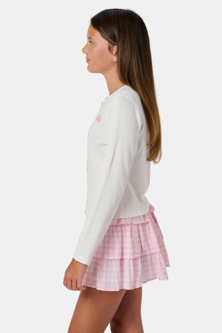 The Roller Rabbit Kids Hearts Pointelle Heidi Cardigan features a white long-sleeve design with playful pink heart details, reminiscent of a classic button-up style, and is displayed against a plain white background.
