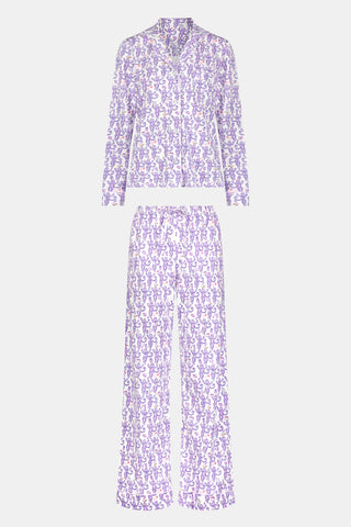 A woman smiles while wearing the TEXPIMA Get Ready With Me Blake Robe, featuring a knee-length cut and a purple and pink paisley pattern, tied at the waist, against a plain white background.