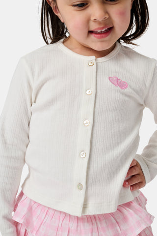 The Roller Rabbit Kids Hearts Pointelle Heidi Cardigan features a white long-sleeve design with playful pink heart details, reminiscent of a classic button-up style, and is displayed against a plain white background.