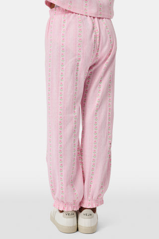 The Kids Daisy Heart Stripe Lucy Pants by Roller Rabbit are crafted from soft Pima cotton genie pant fabric in rose pink, featuring an elastic waistband and cuffs, with a subtle striped pattern and small floral designs throughout—making them a charming addition to girls' fashion.