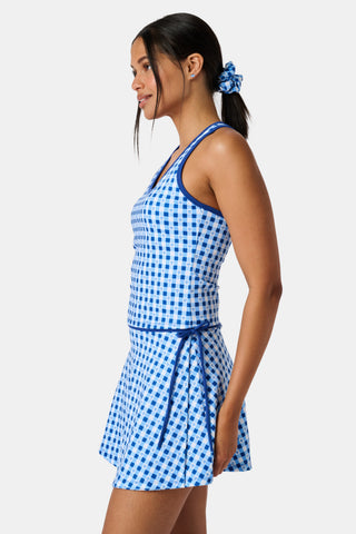 A person wears the Roller Rabbit Gingham Hearts Bella Tank, a blue-and-white checkered racerback style with small heart details. The image is cropped at the shoulders and midsection, showing part of the matching skirt and the person’s head.