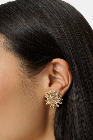 The Roller Rabbit Sunshine Stud Earrings are gold-tone earrings shaped like stylized suns with multiple rays and a spiral center, shown against a plain white background.