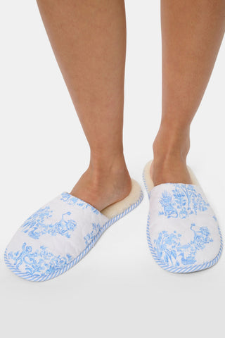 A pair of Sherwood Forest Monkey Quilted Slippers by Roller Rabbit with plush faux-shearling lining and blue floral patterns, displayed side by side on a white background.