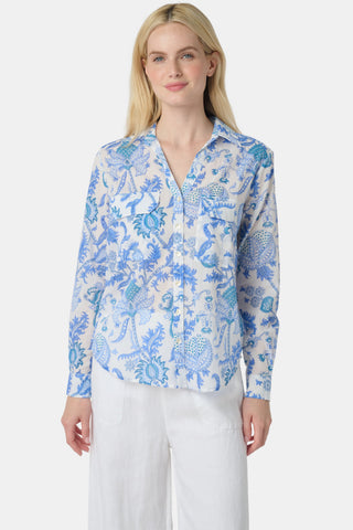 A woman with long blonde hair wears the Roller Rabbit Amanda Guy Shirt, a light blue and white paisley long-sleeve top, paired with white pants, standing against a plain white background.