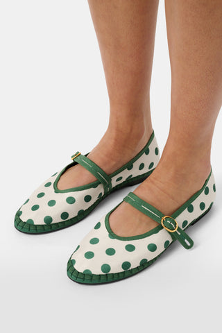 The FLABELUS Polka Dot Pierre is a cream Mary Jane flat with green trim, a green strap featuring a gold buckle, and polka dots—part of the Flabelus collaboration.