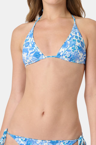 A woman models the Roller Rabbit Amanda/Jemina Serena Bikini Top in blue and white floral print, smiling gently. Her upper torso and lower face are shown against a plain backdrop.