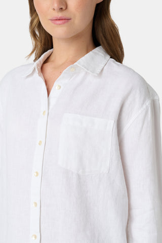 A woman wears the Roller Rabbit Boyfriend Shirt, a menswear-inspired white button-up with a chest pocket, paired with loose white pants featuring a navy polka dot pattern, standing against a plain light background.