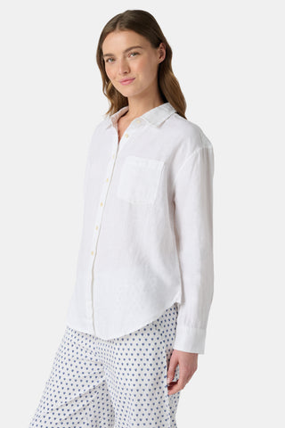 A woman wears the Roller Rabbit Boyfriend Shirt, a menswear-inspired white button-up with a chest pocket, paired with loose white pants featuring a navy polka dot pattern, standing against a plain light background.