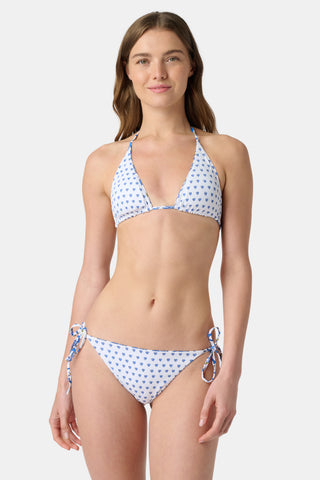 A woman models the Roller Rabbit Monkey/Hearts Serena Bikini Top, a white triangle bikini with blue heart print and UPF 50+ protection, standing against a plain white background and looking at the camera.