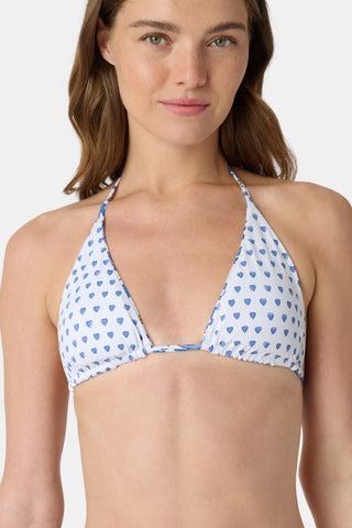 A woman models the Roller Rabbit Monkey/Hearts Serena Bikini Top, a white triangle bikini with blue heart print and UPF 50+ protection, standing against a plain white background and looking at the camera.