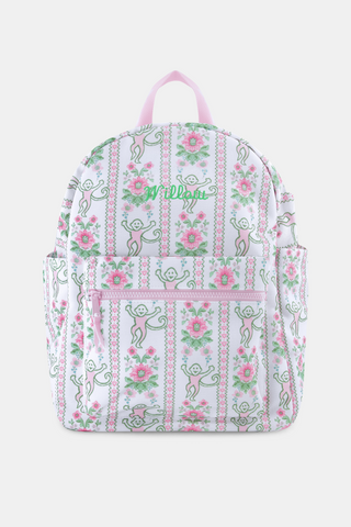 The Roller Rabbit Monkey Block Stripe Backpack is a white bag with pink straps, vertical stripes featuring playful monkeys and pink flowers, plus front and side pockets—an ideal, stylish diaper bag.