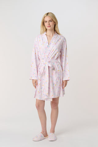 A woman with blonde hair models the Roller Rabbit Candy Heart Stripe Blake Robe—a light pink, knee-length Pima cotton robe with candy heart stripes and a waist tie—against a plain white background.