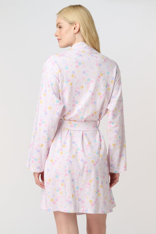 A woman with blonde hair models the Roller Rabbit Candy Heart Stripe Blake Robe—a light pink, knee-length Pima cotton robe with candy heart stripes and a waist tie—against a plain white background.